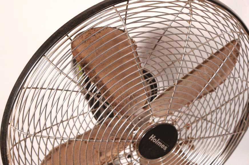 С лопастей напольного вентилятора свисают комки пыли 